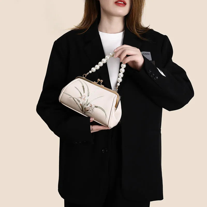 Beige shell-shaped women's shoulder bag with embroidery detail on soft PU leather.