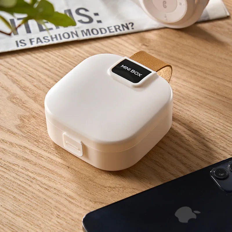 Solid colour plastic Bluetooth headset storage box with lid, 9cm by 4.5cm, in light gray.