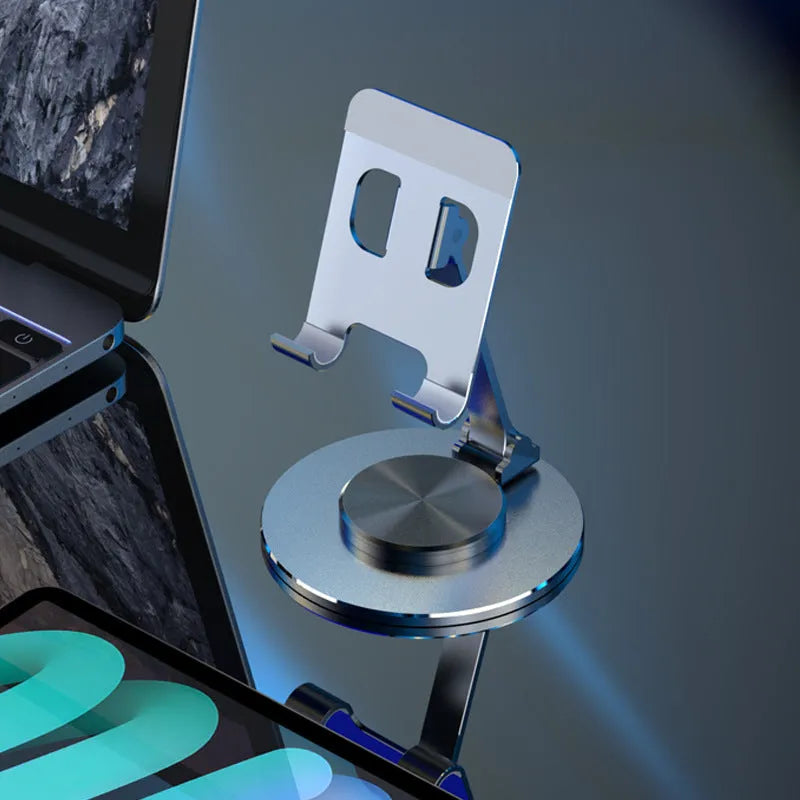 Aluminium alloy rotating mobile phone bracket in silver on a desk, showing three-axis joint and metal texture finish