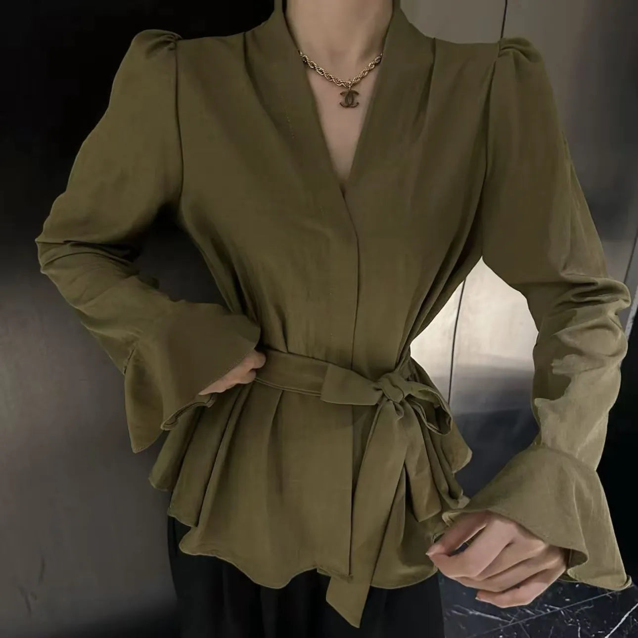 Women's black French-style shirt with an irregular collar and long bell sleeves, tied at the front.