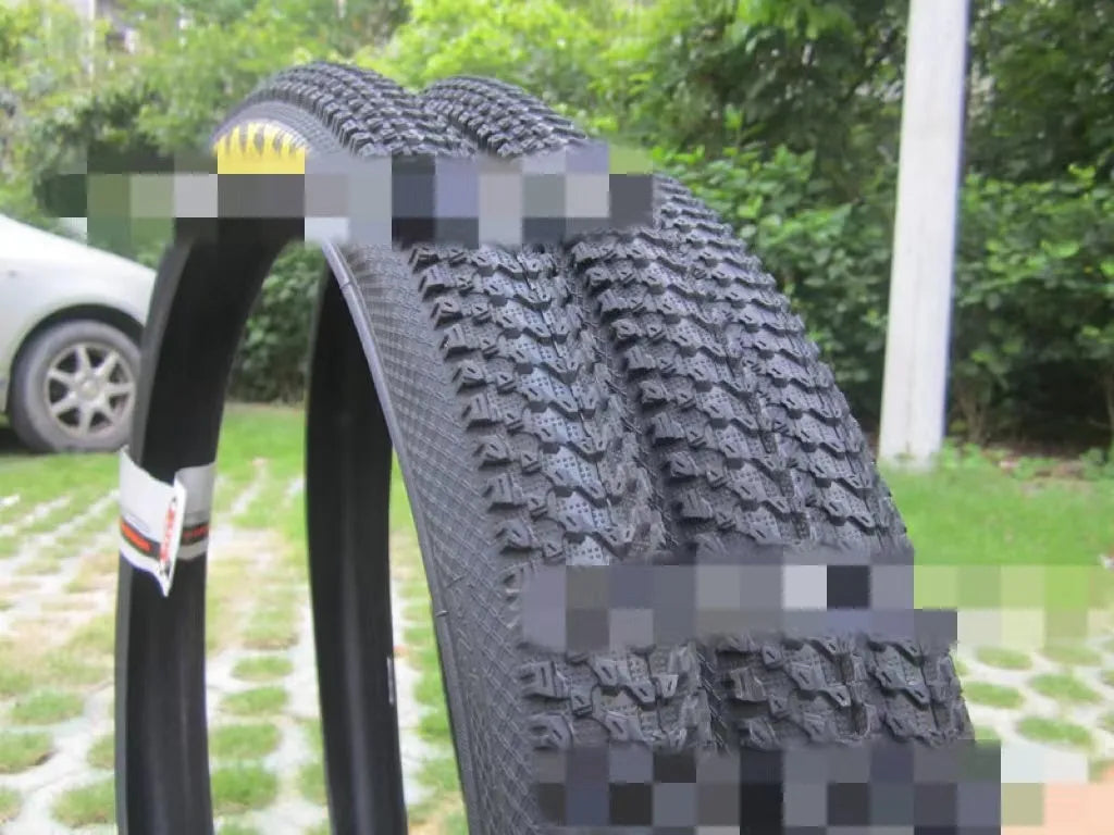 Ultralight mountain bike tyre with black tread and optional white sidewall, shown in sizes 26, 27.5 and 29 inch.