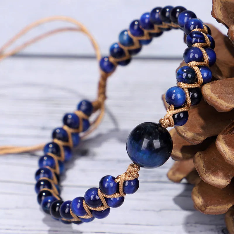 Close-up of a handmade geometric bracelet woven with blue Tigereye stone beads, showing its textured pull-on design.