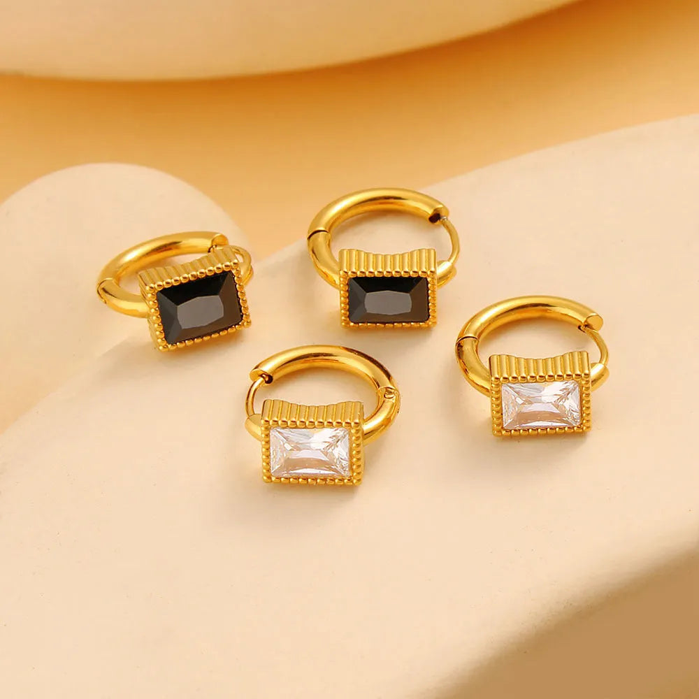 A pair of square-shaped stainless steel earrings with round zircon accents in a choice of black, green, or white.