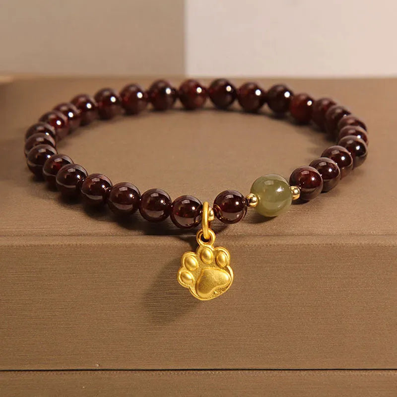 Women's Cat's Paw Garnet crystal bracelet on wrist, original design.