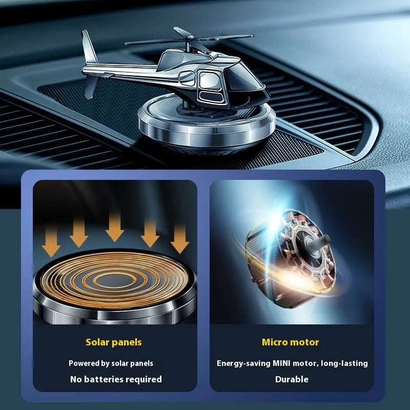 Silver metal solar-powered helicopter car air freshener spinning on a car dashboard