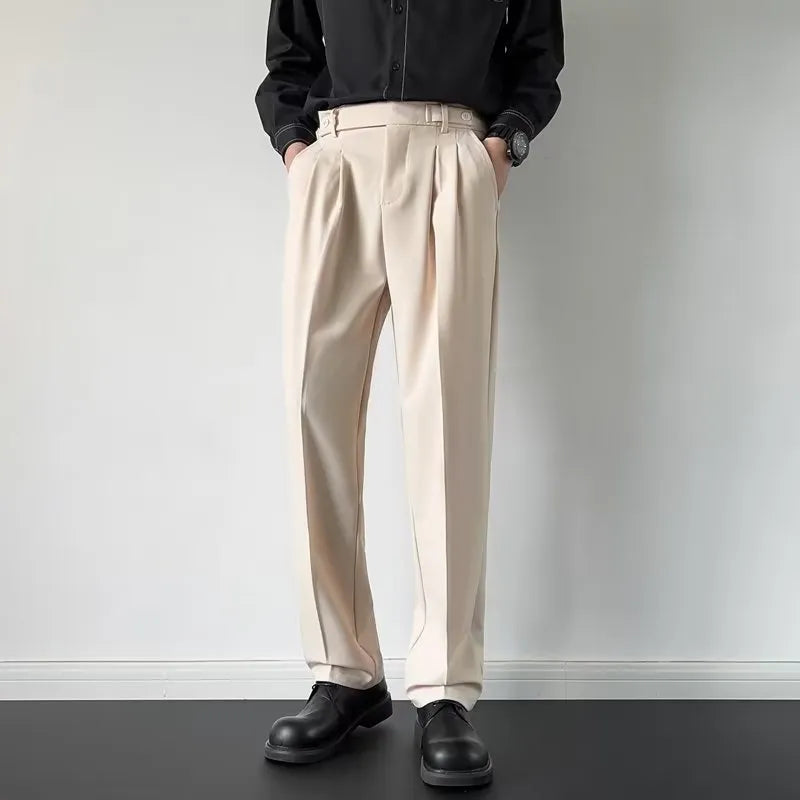 Men's apricot and black straight-leg suit trousers laid flat, showing loose fit and formal design.