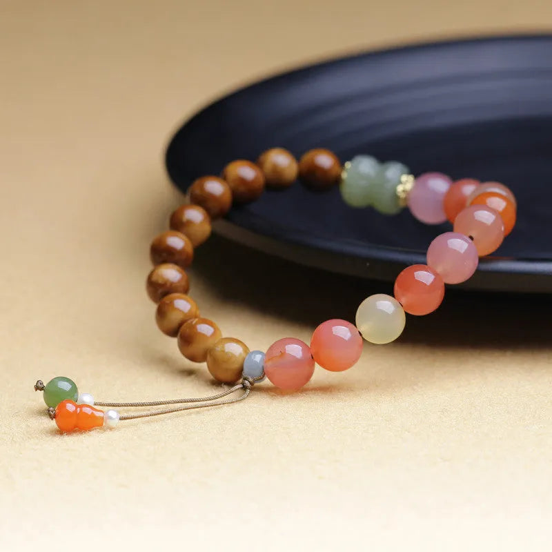 8mm persimmon orange agate bracelet with diamond-shaped beads on wrist