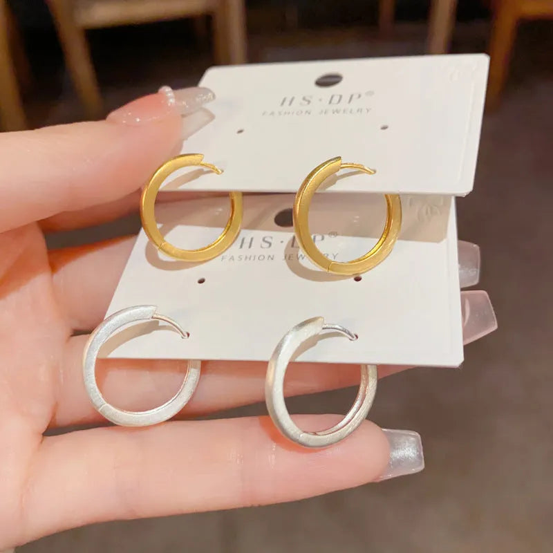 Geometric women's ear clip with round eyelet in gold or silver plating.