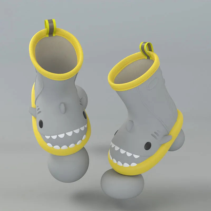 Shark brand children's green rain boots with a dinosaur graphic, showing medium height and plastic construction.
