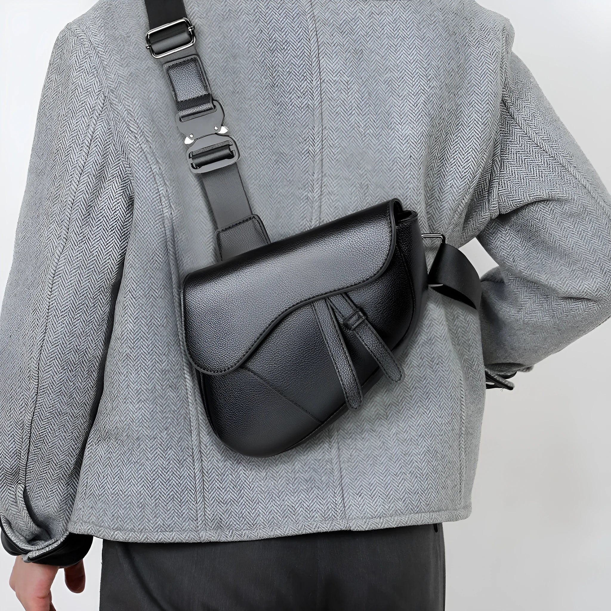 Unisex saddle shoulder crossbody chest bag in black synthetic leather with stitching and splicing details