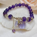 Purple amethyst crystal bracelet with money bag pendant and geometric peace buckle on wrist