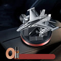 Silver solar-powered rotating fighter aircraft perfume ornament on a surface.