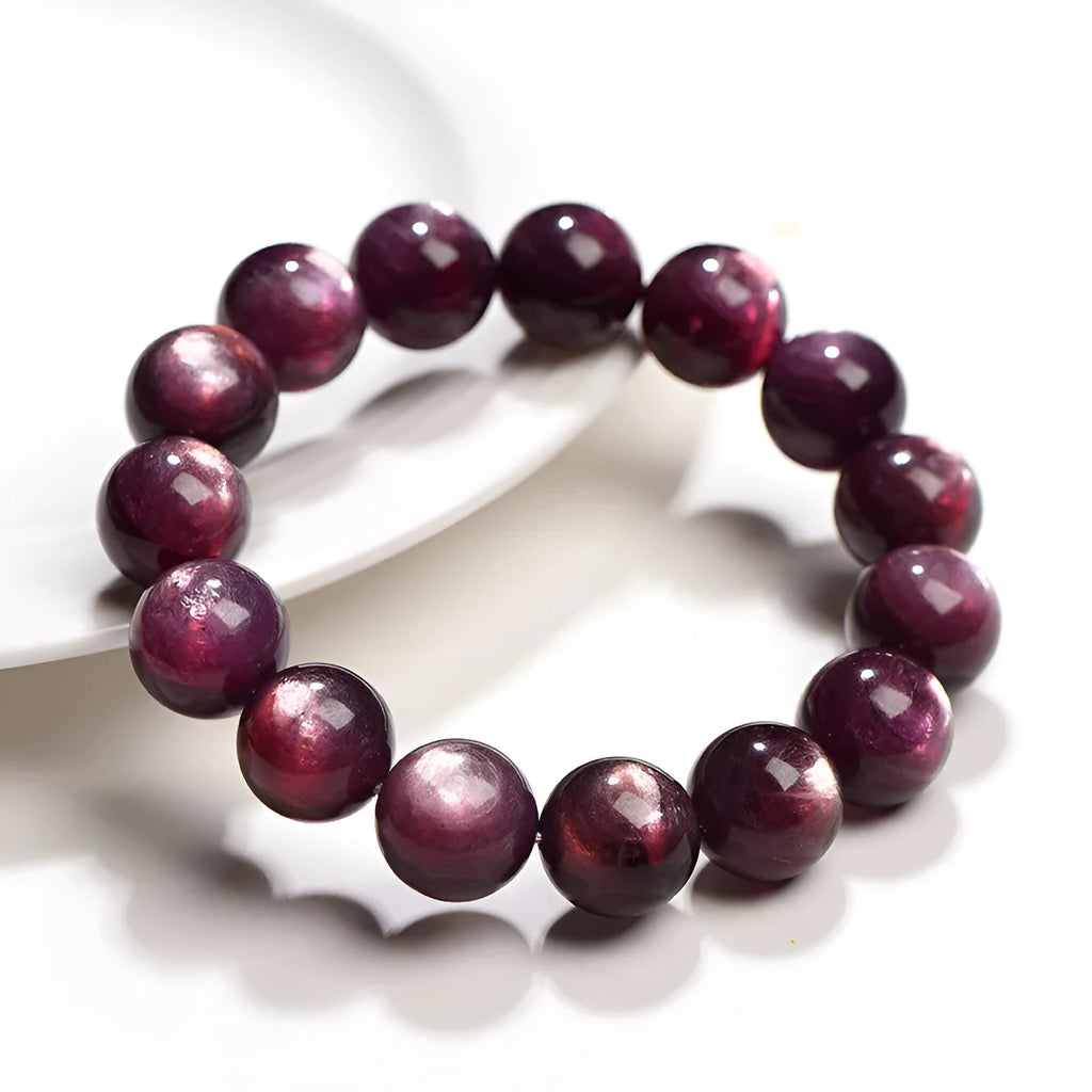 Purple lepidolite crystal round bead bracelet on a wrist, showing polished stones.
