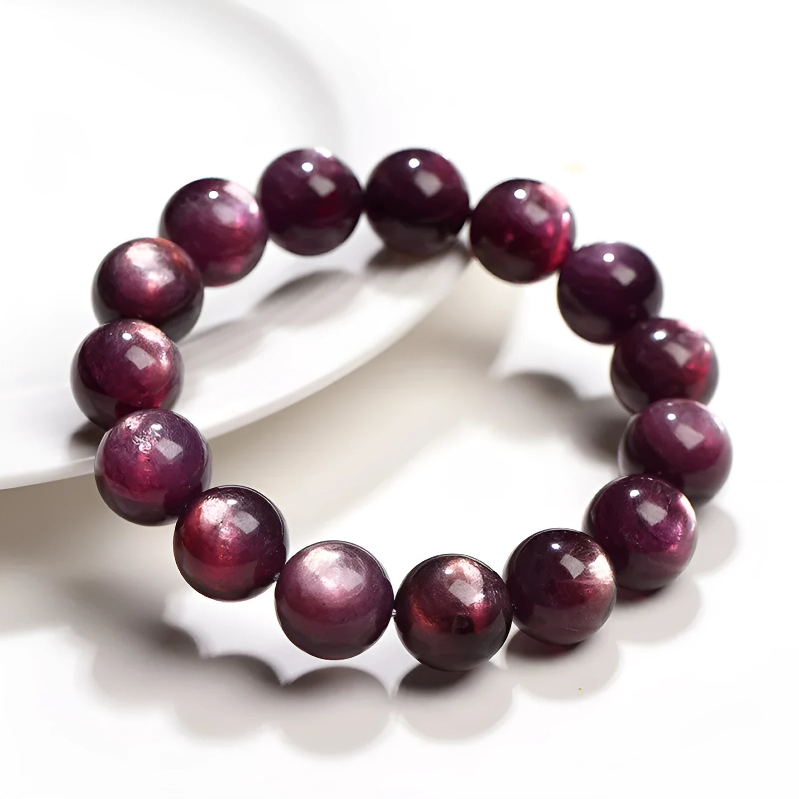 Purple lepidolite crystal round bead bracelet on a wrist, showing polished stones.