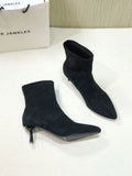 Women's black pointed toe ankle boots with a stiletto heel on a rubber sole.