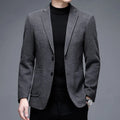 Man wearing a thick grey casual wool-style suit jacket with a loose fit and round hem.