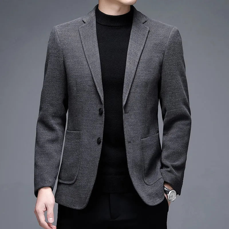 Man wearing a thick grey casual wool-style suit jacket with a loose fit and round hem.