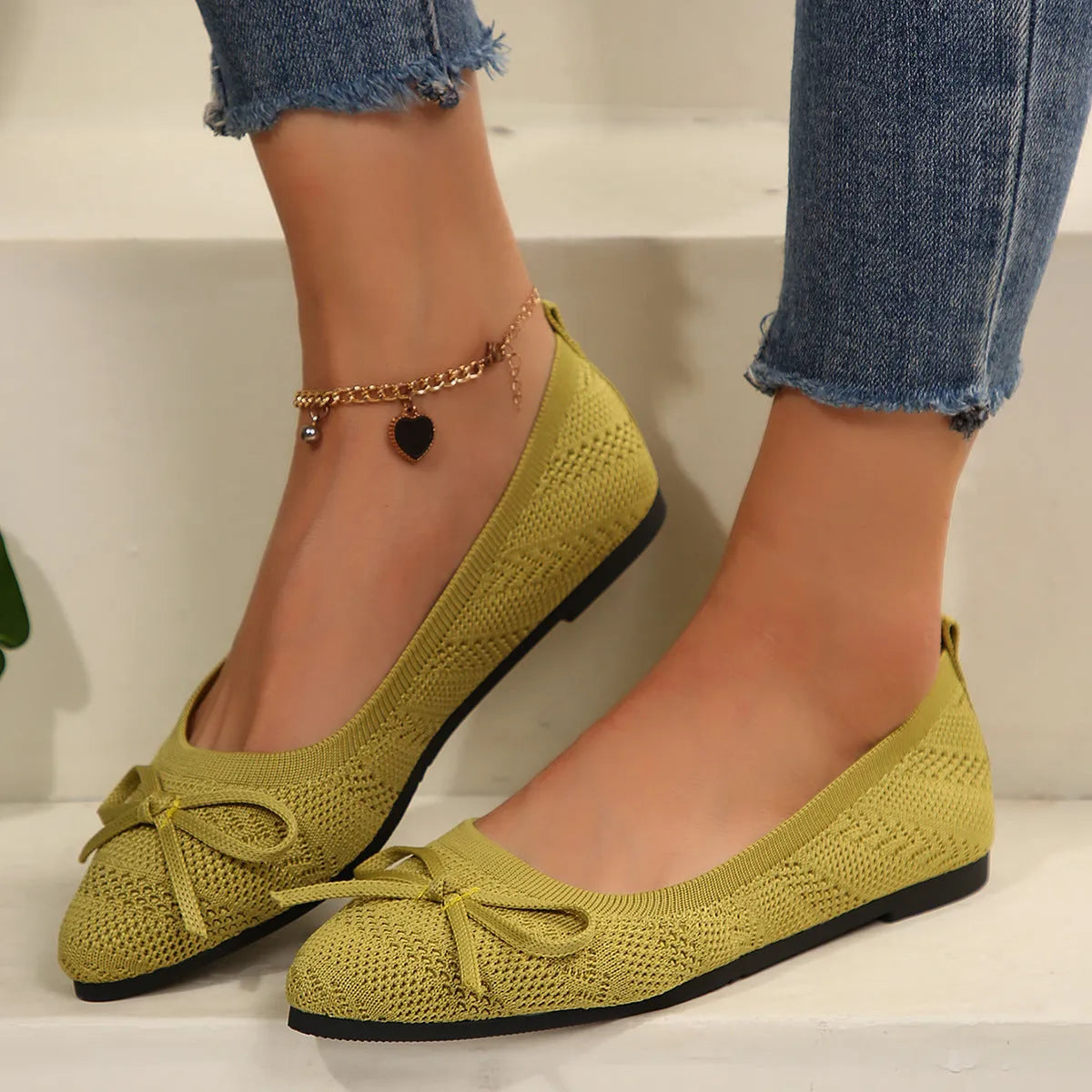 Women's knitted flat loafers with a bow and pointed toe in blue, shown from the side.