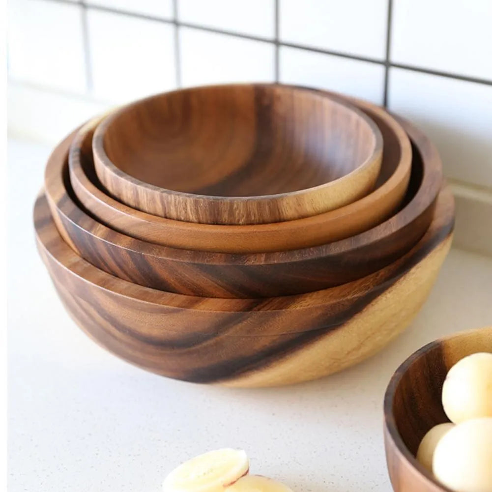 Handmade brown wooden bowl set showing multiple sizes from small to large on wooden table