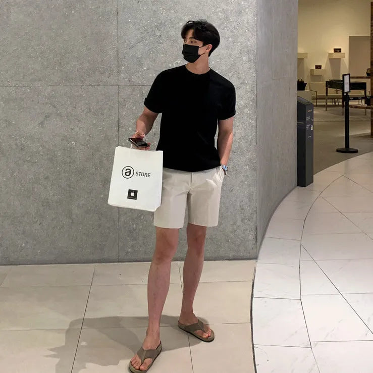 Men's straight-leg polyester shorts in solid black colour showing loose casual fit