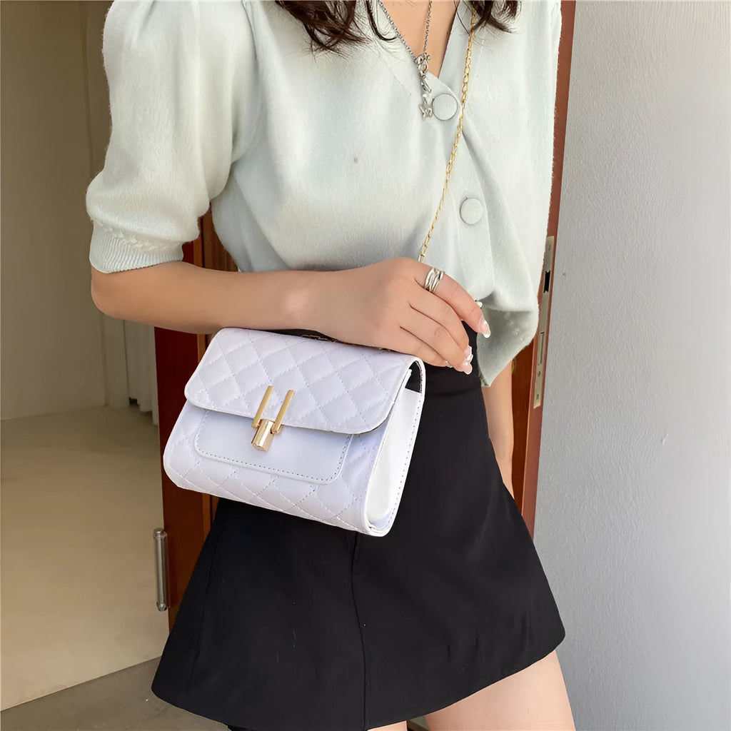 Women's white diamond lattice chain crossbody bag showing adjustable strap and structured shape