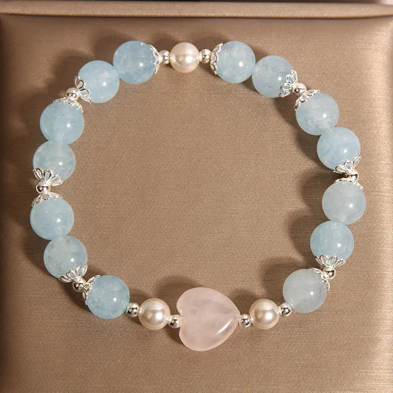 Natural aquamarine crystal bracelet with three shell pearls and lobster clasp on display