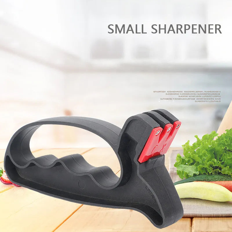 Black handheld knife and scissor sharpener with ergonomic handle on a plain background.