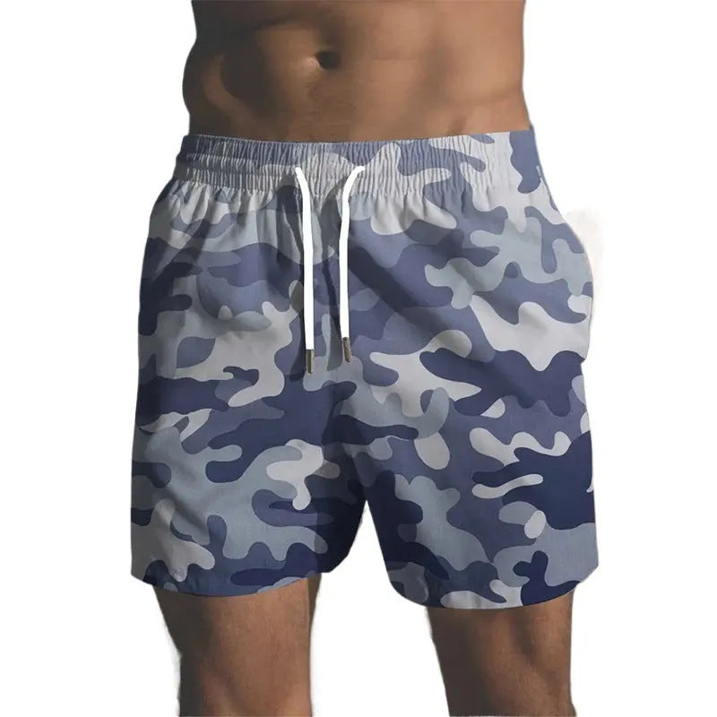 Man wearing coloured print polyester beach shorts with an elastic waistband for summer travel.