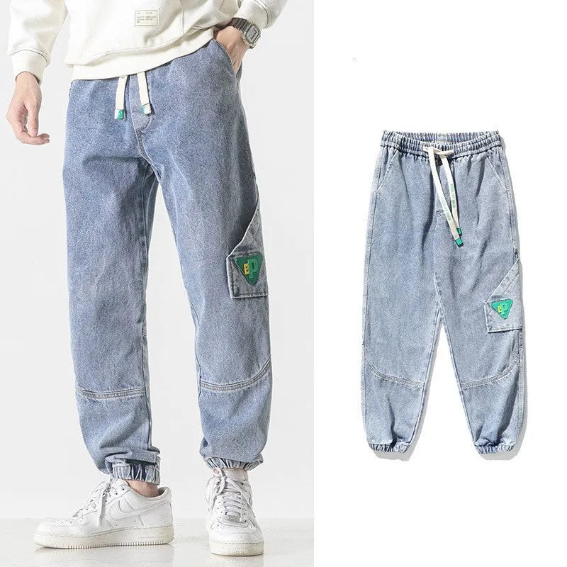 Man wearing grey loose-fit tapered cotton trousers with a mid-rise waist.