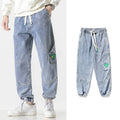Man wearing grey loose-fit tapered cotton trousers with a mid-rise waist.