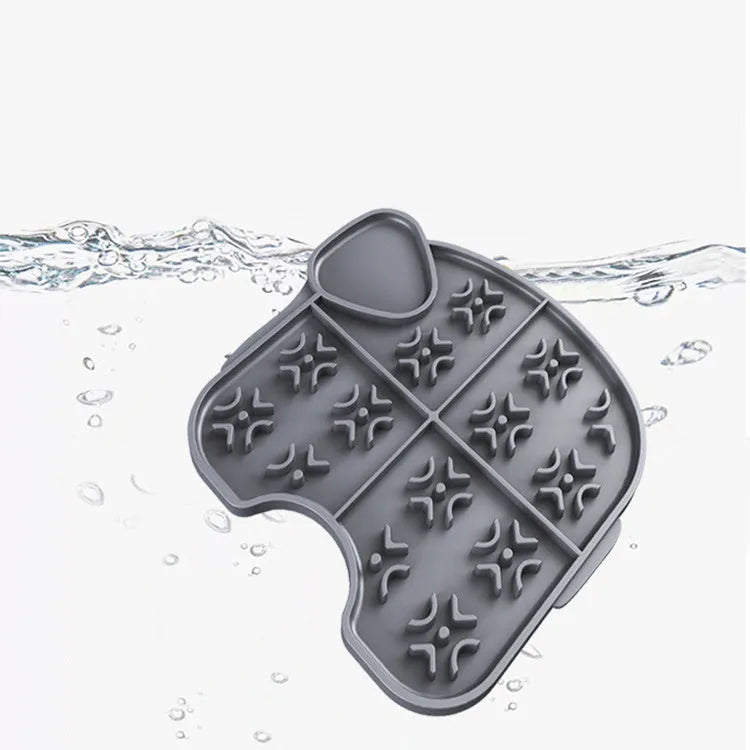 Gray silicone pet slow food pad with suction cups on tile floor, textured surface for licking
