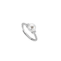 Adjustable geometric twist ring in copper with a central natural pearl on a model's finger.
