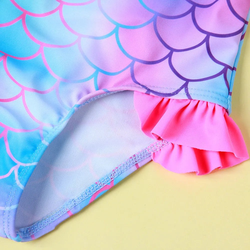 Girls' one-piece swimsuit with blue gradient fish scale print and flounced design.