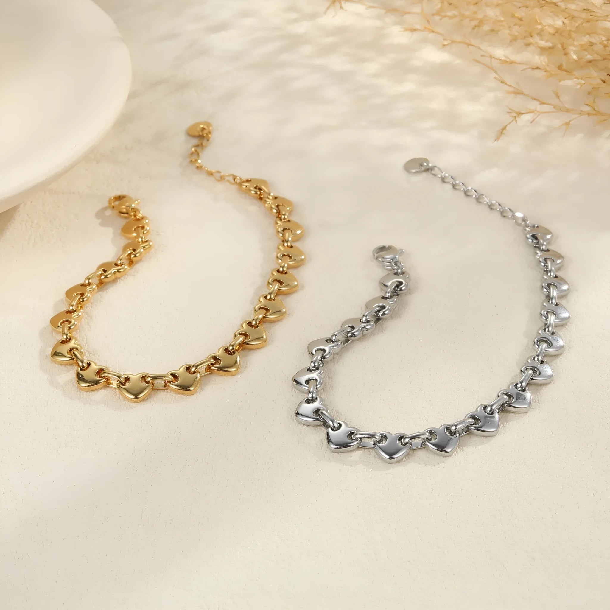 Women's stainless steel bracelet with a hollow geometric heart charm in gold, steel, or colour block finish.