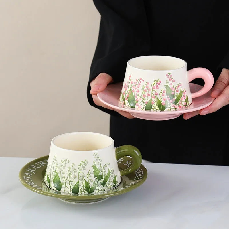 Ceramic coffee cup and saucer set for couples with two cups, saucers, and spoons.