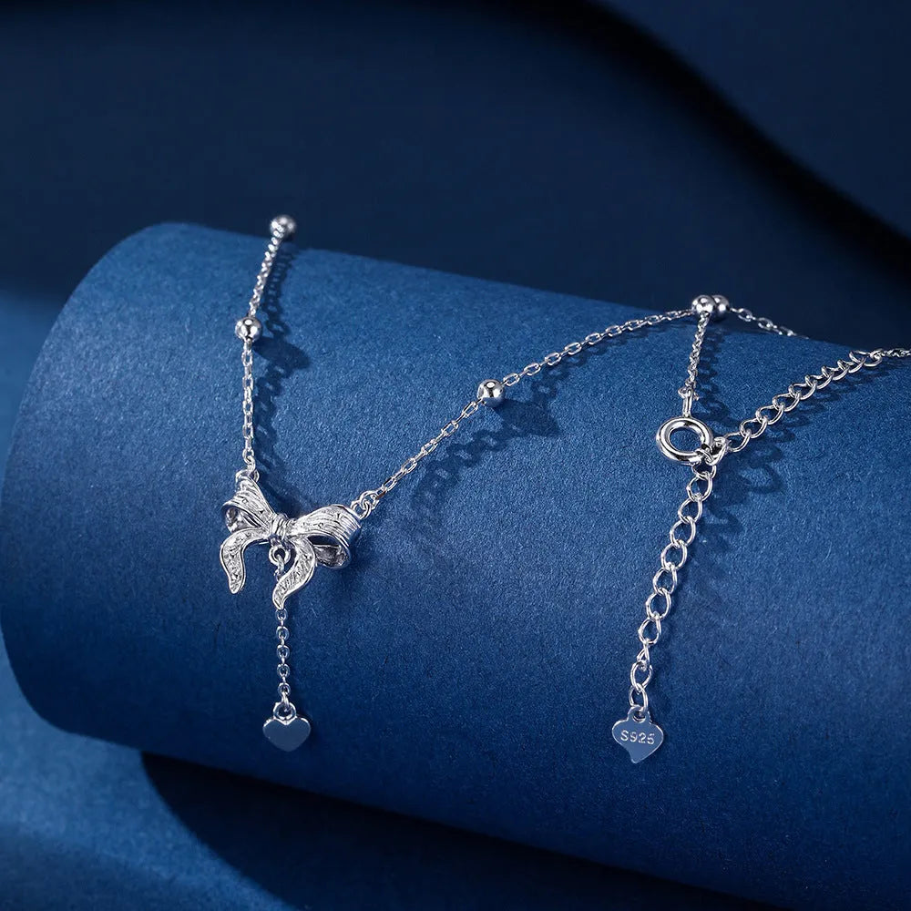 S925 sterling silver necklace with heart and bow pendant on an adjustable O-ring chain.