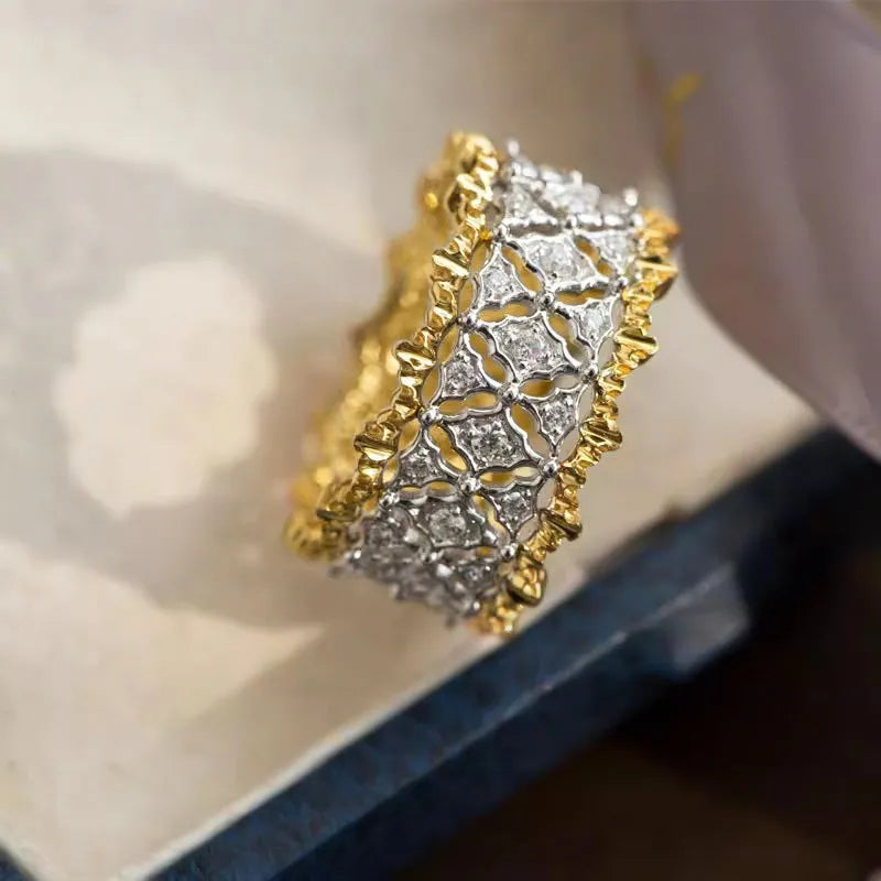 Gold two-tone geometric copper zircon ring on a plain background.