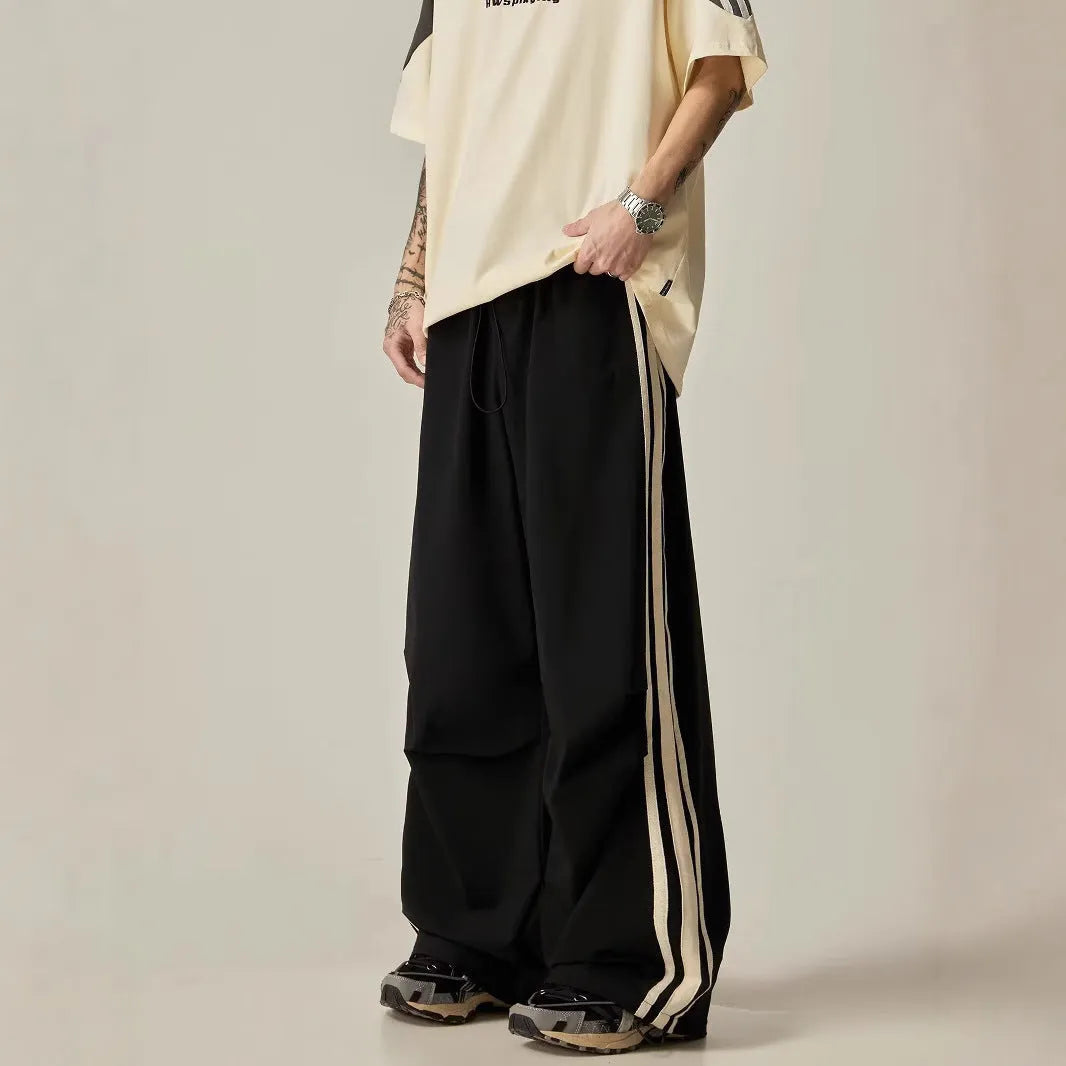 Black men's high-waist wide-leg climbing trousers laid flat, showing straight-leg design.