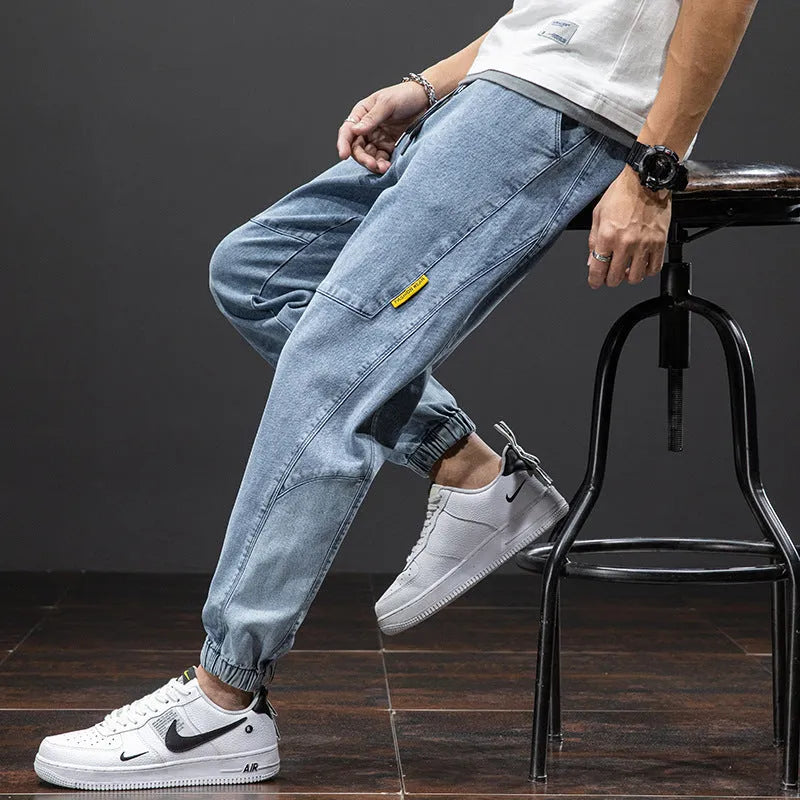 A pair of men's loose-fit cargo jeans in a blue colour, showing the straight leg and casual style.