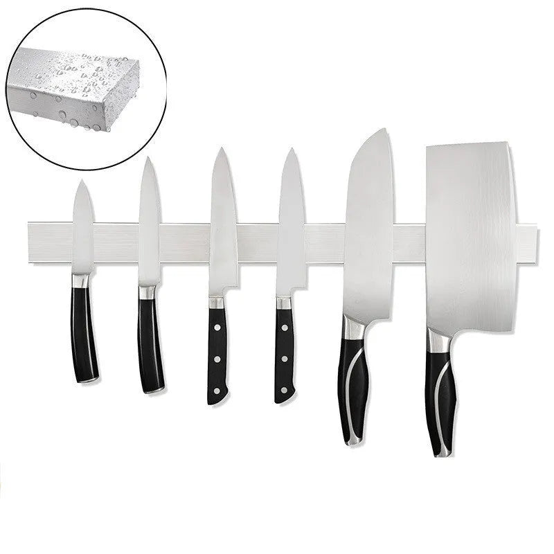 Stainless steel wall-mounted magnetic knife storage rack on a kitchen wall.