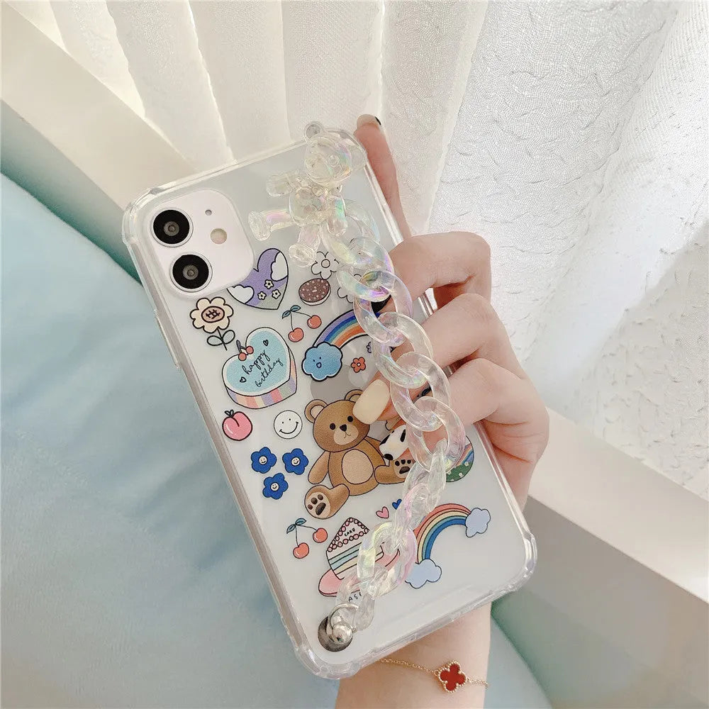 White iPhone case with a cartoon bear design and a connected silver bear pendant on a chain.