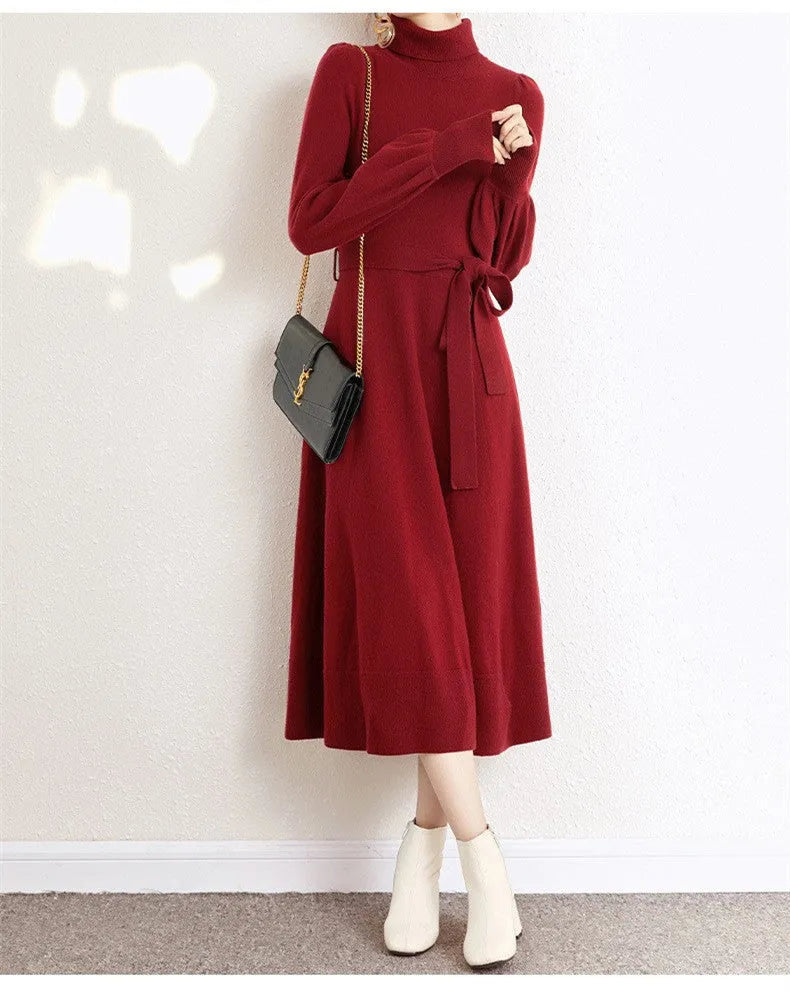 A rose red turtleneck knit dress with long sleeves, a loose hem, and an elastic waist on a hanger.