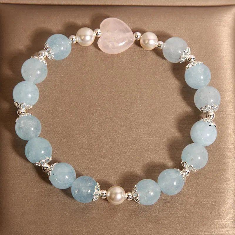 Natural aquamarine crystal bracelet with three shell pearls and lobster clasp on display