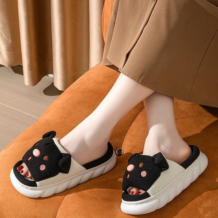 A pair of Piggy Cute linen couple slippers in open toe flip flop style on a plain background.