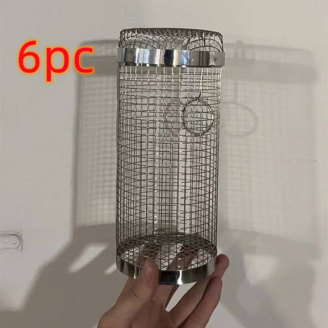Stainless steel cylindrical rolling barbecue grilling basket with wire mesh on a grill.