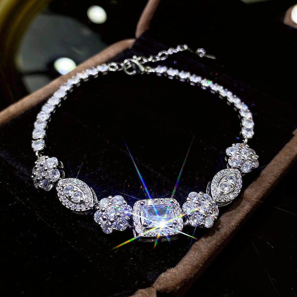 Close-up of a women's geometric silver bracelet with sparkling inlaid zircon stones and a lobster clasp.
