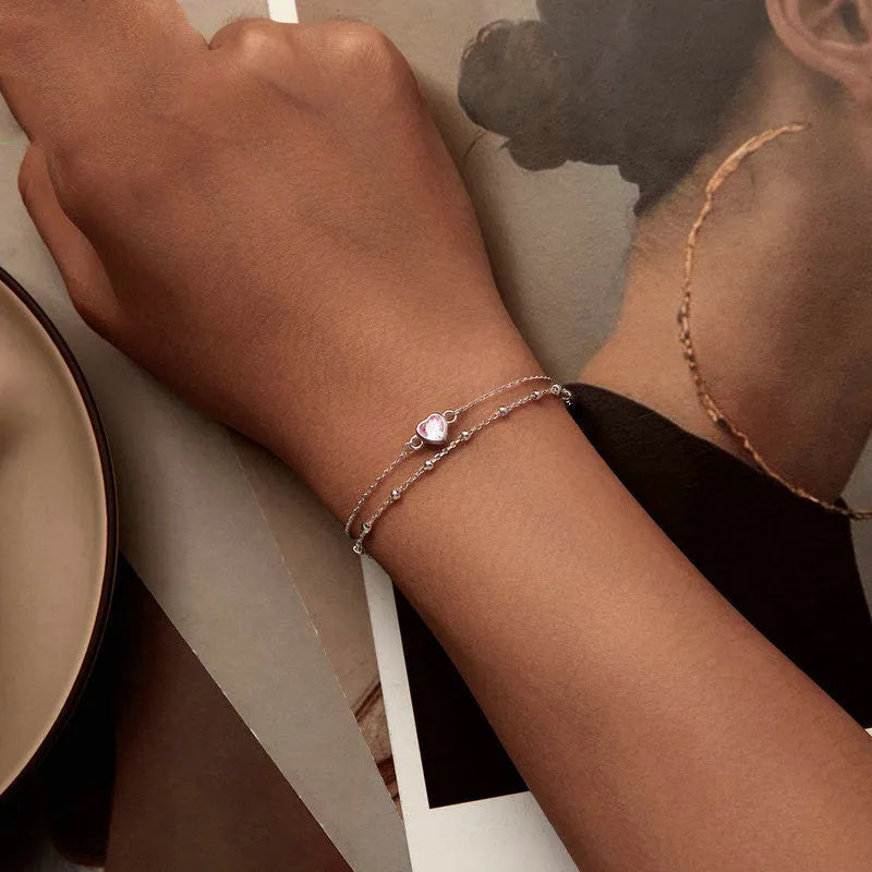 Silver heart-shaped charm bracelet for women on an adjustable chain.