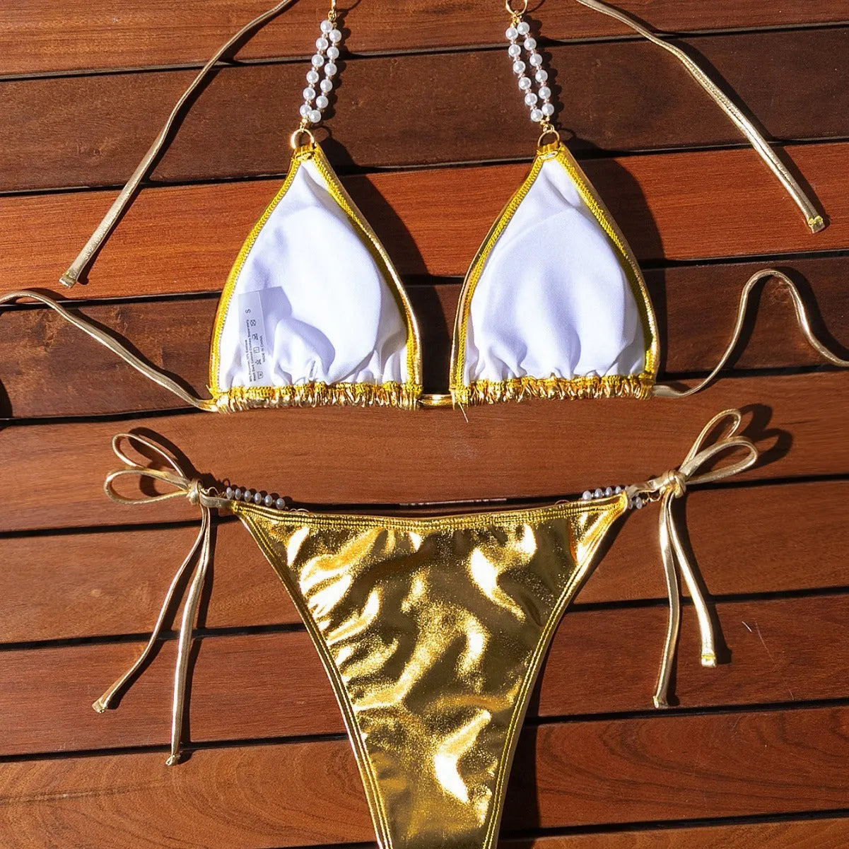 Gold halter neck bikini with lace-up front and pearl chain decoration
