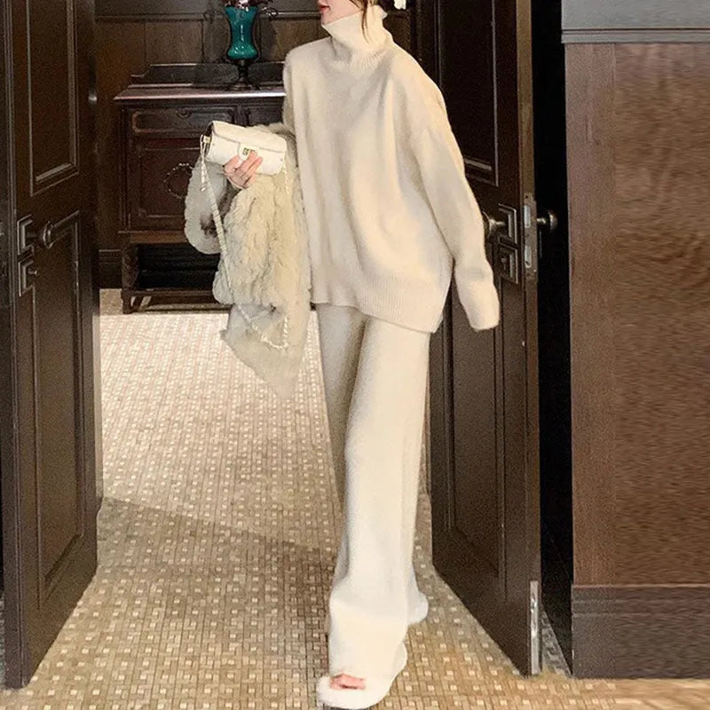 Women's milky white acrylic knit two-piece set featuring a long-sleeve sweater and wide-leg trousers on a hanger.