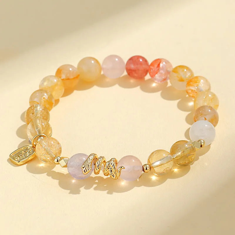 Women's crystal bracelet with Fu snake charm and plastic flower beads on wrist